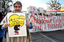 Hombre sosteniendo cartel "¡NO AL CAPITALISMO SALVAJE. NO A LA POLAR COMO MODELO EDUCACIONAL!"