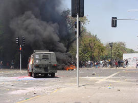 Carro lanza-gases frente a barricada en manifestación social