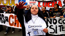 Mujer vestida de monja con cartel "EDUCACIÓN PURA"
