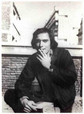 Sergio Reyes, sentado fumando con libro en la mano