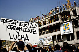 Persona sosteniendo cartel "¡¡DESPIERTA!! ORGANÍZATE Y LUCHA"