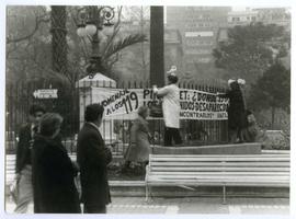 Fotografía de mujeres poniendo lienzo sobre Detenidos Desaparecidos en Plaza de Armas