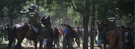 Carabineros a caballo dispersando personas en parque