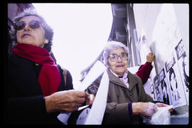 Hilda Saldívar y Doris Meniconi pegando afiches en el frontis de Londres 38, ex centro de detención y tortura