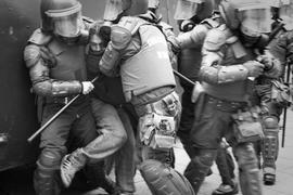 Persona siendo arrestada por 5 carabineros de Chile durante manifestación