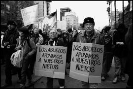 Personas mayores con cartel "LOS ABUELOS APOYAMOS A NUESTROS NIETOS"