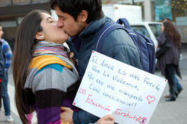 Pareja besándose con cartel "EL AMOR ES MAS FUERTE QUE LA VIOLENCIA..."