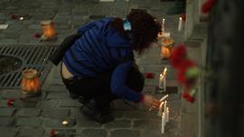Mujer dejando vela en actividad conmemorativa por el Golpe de Estado en Chile