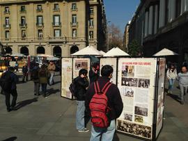 Personas observando la exposición itinerante "Montajes comunicacionales del pasado y del presente"