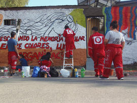 Personas pintando mural en población Nueva La Habana