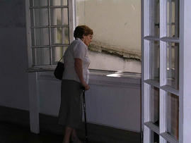 Blanca Troncoso mirando desde ventana del inmueble ubicado en Londres 38
