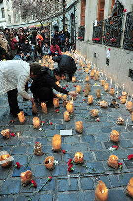 Mujeres encendiendo velas en frontis de Londres 38 durante conmemoración del 11 de septiembre