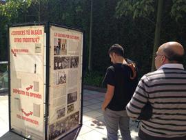 Personas observando la exposición itinerante "Montajes comunicacionales del pasado y del presente"
