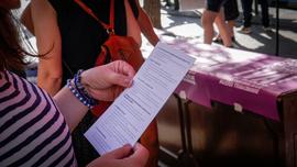 Mujer leyendo folleto "Síntesis del Encuentro Plurinacional de Mujeres que Luchan"