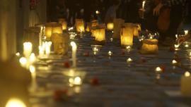 Velas y claveles sobre adoquines conmemorativos en Londres 38 durante actividad por Golpe de Estado en Chile