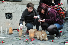 Mujeres encendiendo velas en frontis de Londres 38 durante conmemoración del 11 de septiembre