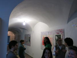 Personas observando afiches de la Brigada 40 años en exhibición en Nápoles