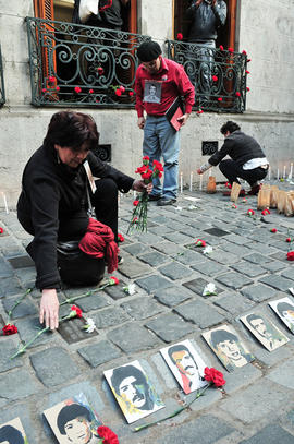 Mujer dejando clavel rojo en frontis de Londres 38 durante conmemoración del 11 de septiembre