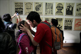 Pareja besandose frente a exposición de afiche