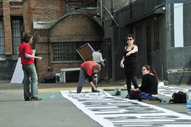 4 personas preparando lienzos para la intervención urbana "Puentes de la Memoria"