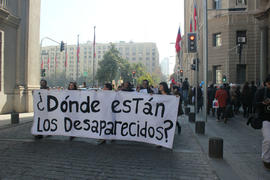 Personas marchando con cartel hacia La Moneda